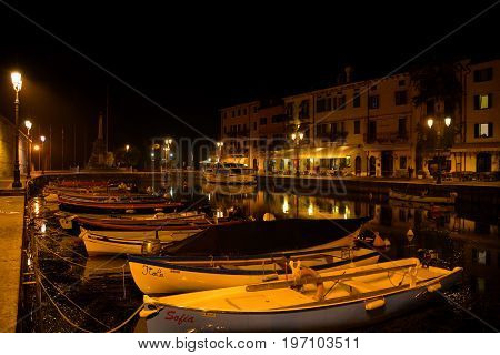 Lazise Italy,October 21st 2013.Nighttime scene of the marina with boats and buildings in Lazise Italy situated on Lake Garda Italy's biggest lake.Cone to Lazise and relax.