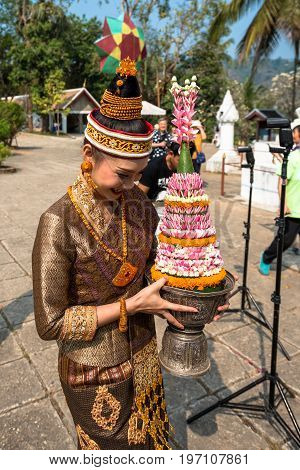 LUANG PRABANG LAOS - MARCH 11 2017: Lao woman dressing with traditional clothes for a ceremony at Wat Xieng Thong Buddhist temple located in the city Luang Prabang Laos.