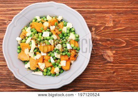 Warm salad with roasted pumpkin, peas and cheese brie. Low fat healthy eating concept.