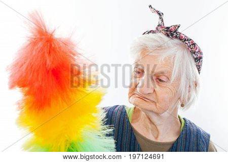 Portrait of a happy senior lady doing housework holding cleaning equipment