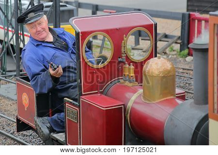 HASTINGS, UK - JULY 23, 2017: Close-up on the driver of a steam train at the Hastings Miniature Railway located at Rock-a-Nore Road