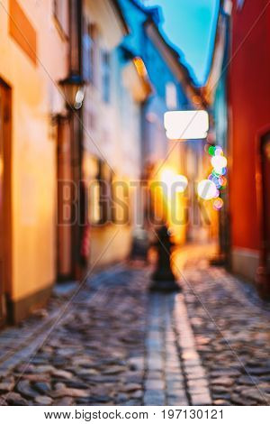 Riga, Latvia. Abstract Blurred Boke Bokeh Background Of Troksnu Street In Lighting At Evening Illumination.