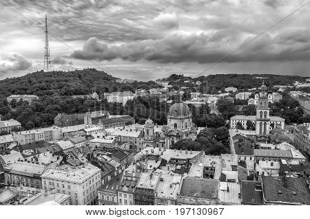 Lviv Ukraine old city vintage toned top view panorama with houses roofs. High Castle park Dominican Church Korniakt Tower Dormition Assumption church television tower Black and white