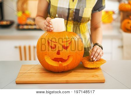 Closeup On Woman Putting Candle Inside Pumpkin Jack-o-lantern