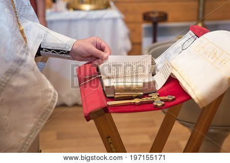 church utensil on an altar glans cross on the church altarthe Bible on the table ceremony of water christening priest holds a bible on a table