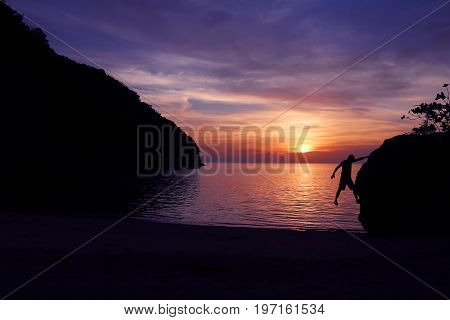 Rock climbing with sunset on the beach in Thailand.