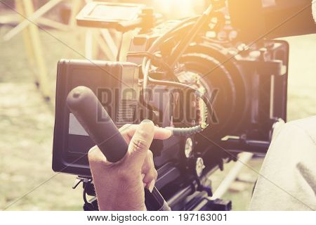 Cameraman with his video camera shooting, Hands Adjusting Camera,film production crew, behind the scenes background.