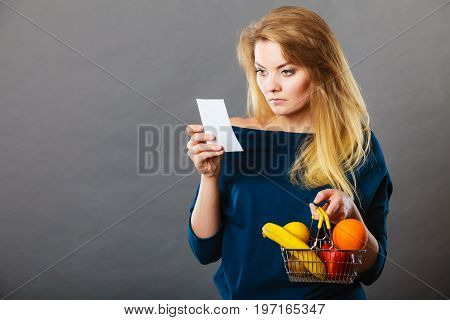 Worried Woman Holding Shopping Basket With Fruits