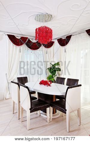 White glossy table with leather chairs in white classical interior
