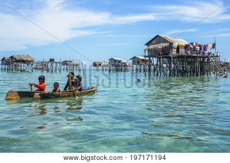 Semporna,Sabah,Malaysia-Apr 23,2017:Sea Gypsy kids on unique handmade boats surrounded by beautiful clear water of the Bodgaya island,Semporna,Sabah,Malaysia.