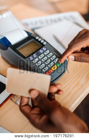 Cropped View Of African American Waiter Working With Credit Card And Terminal In Coffee Shop