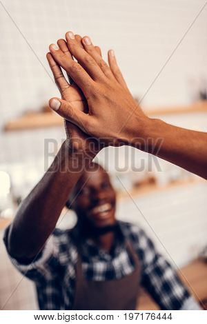 African American Barista Giving Highfive To Client In Coffee Shop