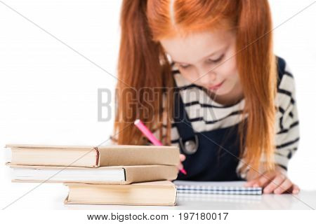 Close-up View Of Books On Desk And Schoolgirl Drawing With Felt Tip Pen Isolated On White