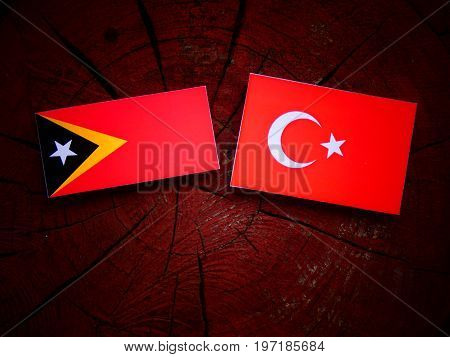 East Timorese Flag With Turkish Flag On A Tree Stump Isolated