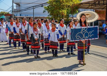 CHIANGMAI THAILAND - JANUARY 25 2015: Hill Tribe people with traditional costume holding board of Lua nationality name in parade of 22nd Traditional Skirt Fabric and The Indigenous Product and Culture Festival in Mae Chaem Chiangmai Thailand
