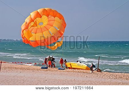 SOUSSE, TUNISIA - APRIL 28, 2008: Unidentified people are trying to open parachute on the windy weather