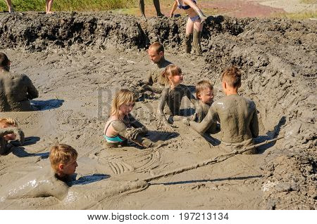 Kuchugury, Russia - July 16, 2017: Azov scorching heat mud volcano. People take procedures with healing mud