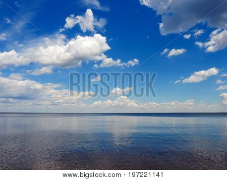 Calm tranquilly scene of beautiful sky with cumulus clouds reflection on the sea