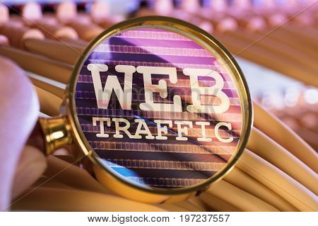 Cropped image of hand analyzing web traffic through magnifying glass over cables in server room