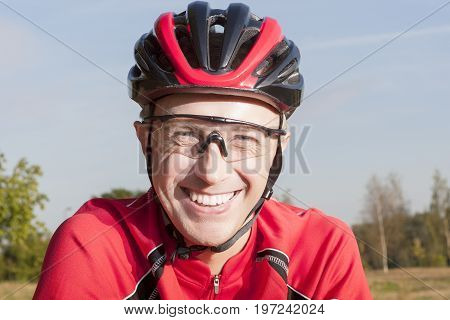 Portrait of Positive caucasian Male Road Cyclist Posing Outdoors in Helmet and Sport Outfit.Horizontal Image