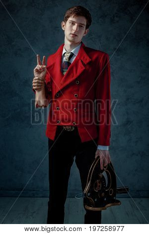 The magician in the red jacket stays with a guillotine and fake severed hand.