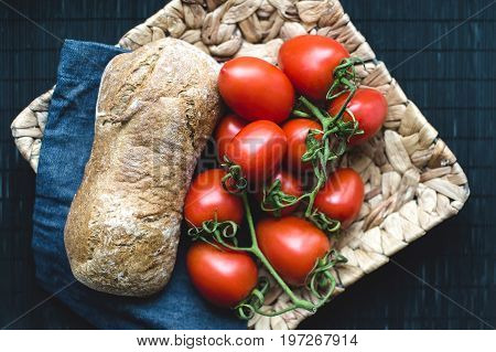 Tasty bred and tomatos on wicker plate
