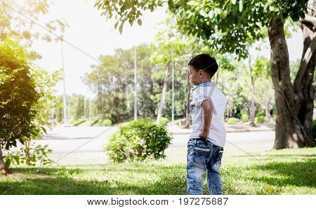 Happy child blowing soap bubbles in spring park with lens flares