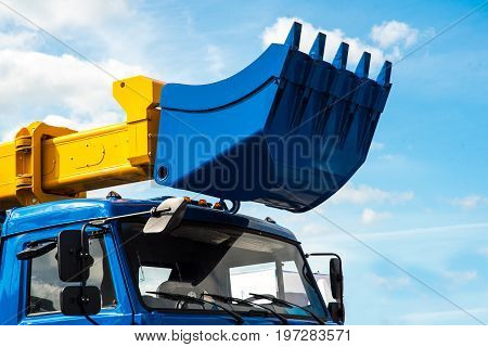 Close-up of a construction site excavator on blue sky