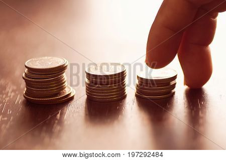 finger step on staced of coin money concept in grow and walk step by step for success in business