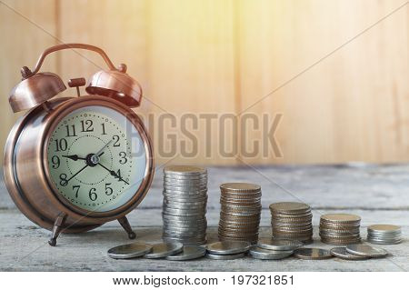 alarm clock and staced of coin .concept in grow and walk step by step for success in business