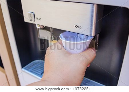Drinking water using a paper cup for drinking water is a proper way to drink hygiene water and beverages. at water cooler water dispenser