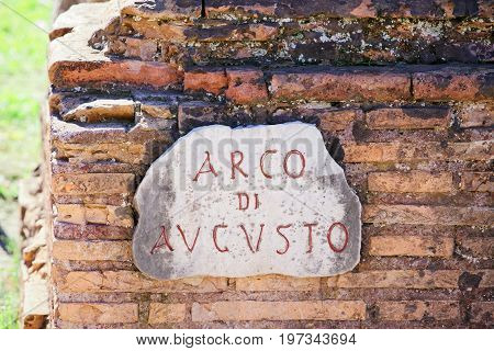 Arco Di Augusto Sign On Brick Wall In Rome