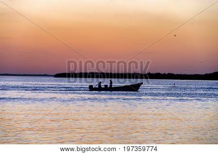 Men fishing at sunset in Rio Lagartos in Mexico