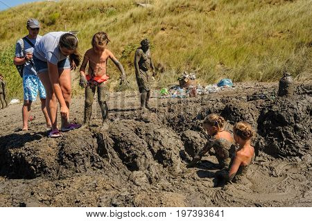 Kuchugury, Russia - July 16, 2017: Azov scorching heat mud volcano. People take procedures with healing mud