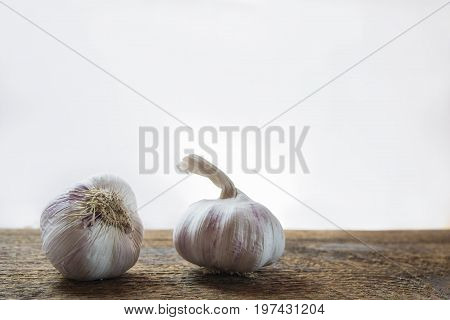 Two pieces of purple garlic on the wood