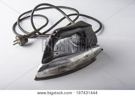 Old electric iron on the white background with the cord