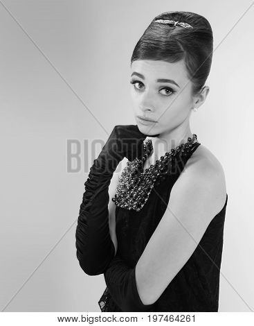 beautiful young woman in retro style with her hair in little black dress