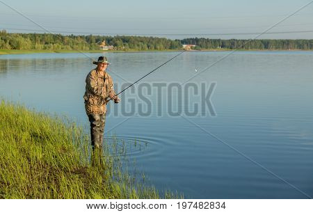 The fisherman catches a pike for spinning off the bank of the channel