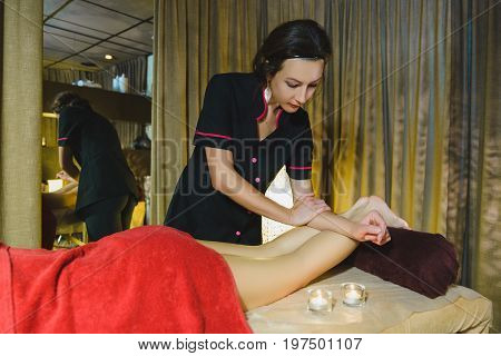 Woman having face massage treatment in wellness center.