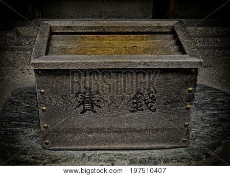 Japanese money box used in temples people throw money in and then pray and make a wish. With a vignette.