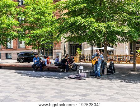 Montreal Canada - May 28 2017: Old town area with guitar musician in place d'arms square during morning day outside Notre Dame Basilica church in Quebec region city