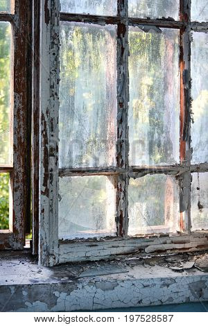 Old window with shabby cracked paint In the old forgotten house