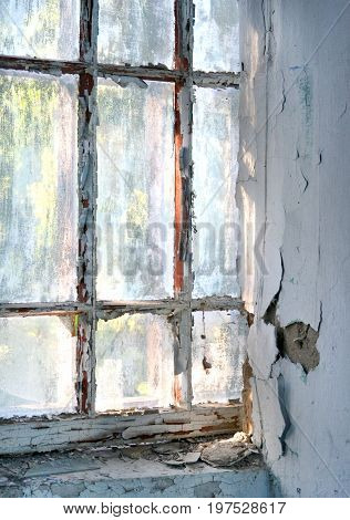 Old window with shabby cracked paint In the old forgotten house