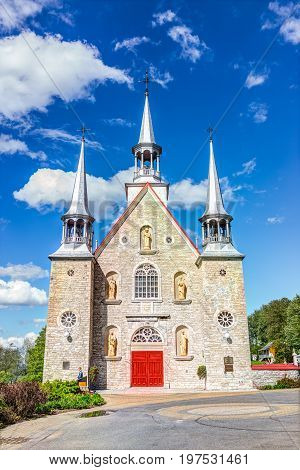 Ile D'Orleans Canada - June 1 2017: Sainte-Famille red painted church with stone architecture and blue sky in summer