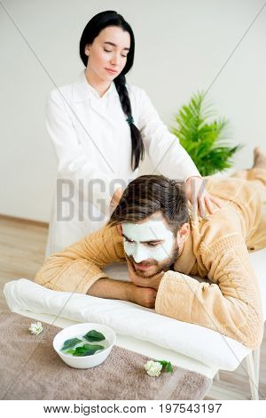 Man relaxing on massage table in spa salon