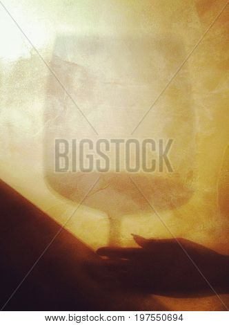 Secretly reaching for a glass of wine - abstract shadow game. Drinking wine in secret.