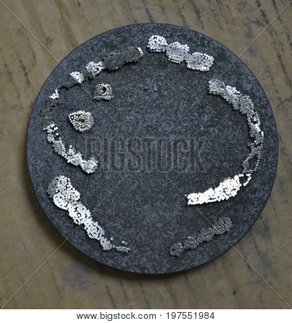 The working disk of the laser unit for melting the metal and the remains of the model printed on it