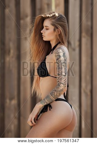 Sexy tattooed woman in lingerie in a river water.Sexy young woman relaxing on the beach.