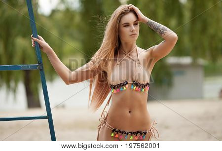 Sexy tattooed woman in lingerie in a river water.Sexy young woman relaxing on the beach.