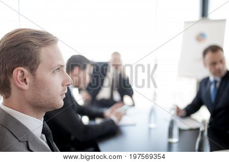 Close-up portrait of thougtful business man at meetig in office